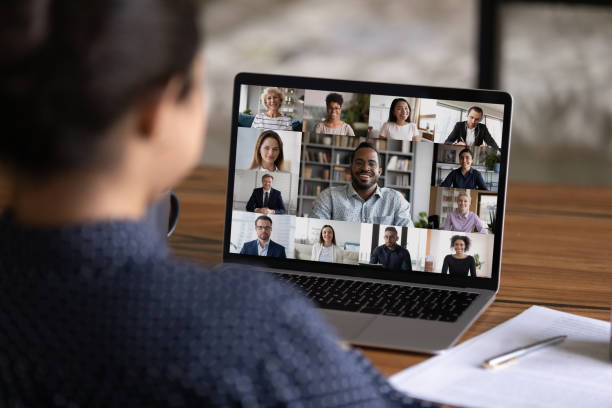 Rear view of woman talk on video call with colleagues Over shoulder view of female worker have webcam digital virtual conference with diverse multiethnic colleagues. Woman speak talk on video call with multiracial businesspeople. Online meeting concept. conference call stock pictures, royalty-free photos & images