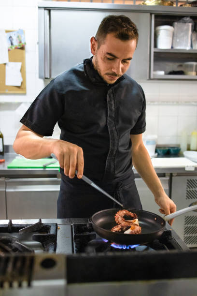 istock Young chef is preparing a typical with octopus dish of the restaurant. She brings to the table good and tasty cuisine 1282984264