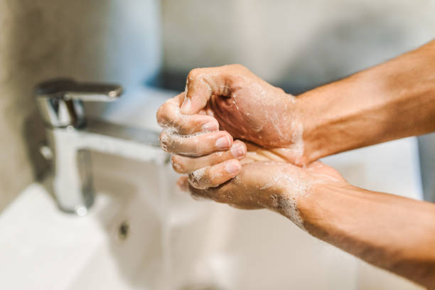 Unrecognizable man washing his hands with a soap. Coronavirus prevention /  hygiene concept. Things to do to stop spreading coronavirus stock photo Unrecognizable man washing his hands. Coronavirus prevention /  hygiene concept. Things to do to stop spreading coronavirus stock photo obsessive stock pictures, royalty-free photos & images