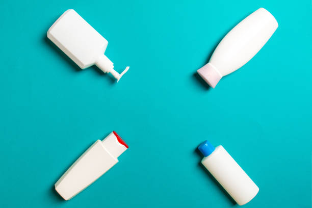 istock Set of White Cosmetic containers isolated on colored background, top view with copy space. Group of plastic bodycare bottle containers with empty space for you design 1282985581