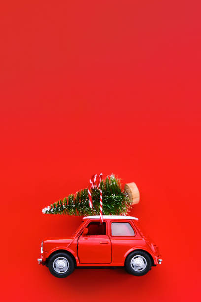 istock Little red toy car and Christmas tree on a red background 1282986493
