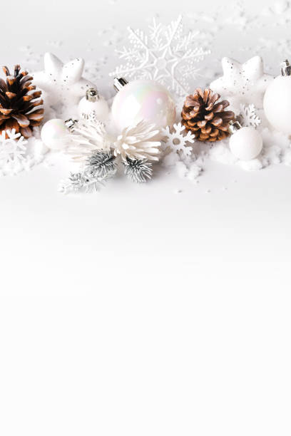 istock Silver and white Christmas balls and ornaments on white snow background 1282986877