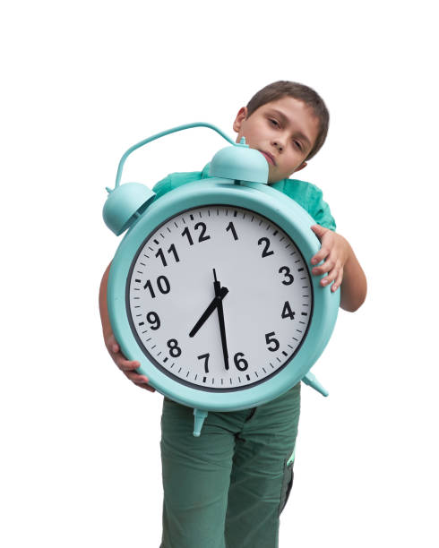 istock Schools start too early. Little boy with large gren alarm clock 1282987916