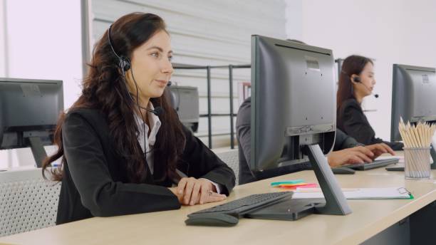 istock Business people wearing headset working in office 1282988415