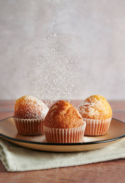 istock Sprinkling icing sugar over freshly baked muffins, homemade cakes. 1282994055