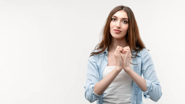 istock Pretty Young woman making heart symbol by hands. Romantic concept. Studio shot, white background. Copy space 1282995158