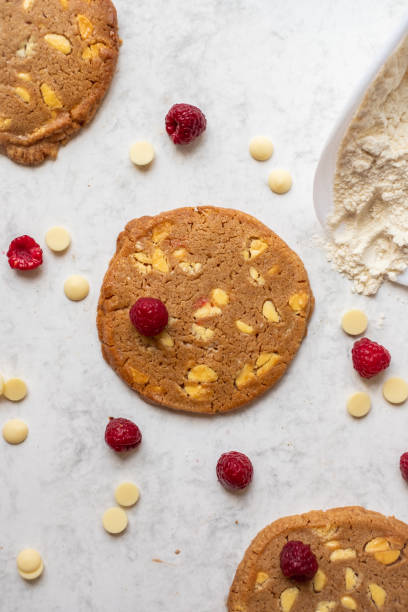 White chocolate and raspberry cookie on a white marble table view from top Top view of fresh biscuits chocolate white chocolate chocolate chip white stock pictures, royalty-free photos & images