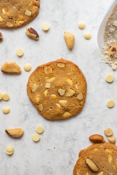 istock Homemade white chocolate and brazil nut cookies on a white marble table view from top 1282995337