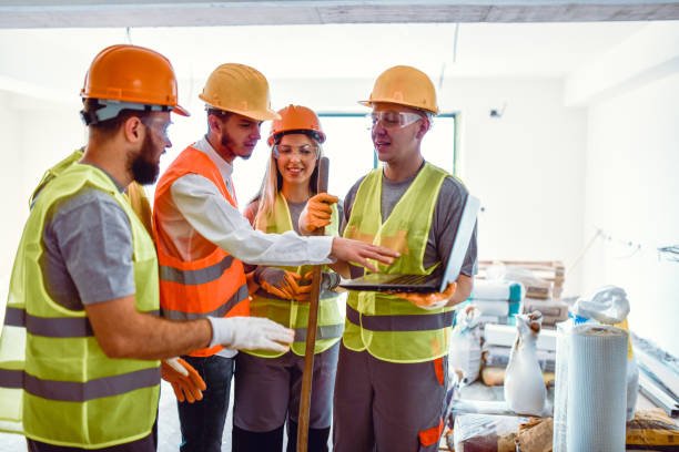 Construction Team Analyzing Plan From Laptop Before Work Construction Team Analyzing Plan From Laptop Before Work helmet hardhat protective glove safety stock pictures, royalty-free photos & images