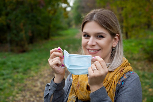 istock Woman putting on mask outdoor 1283000865