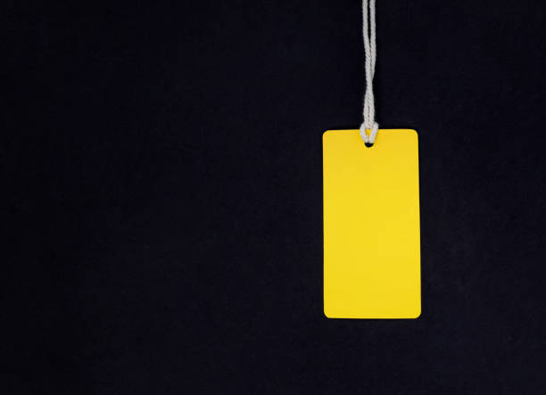istock Mock up of yellow paper label on a black background. 1283002048