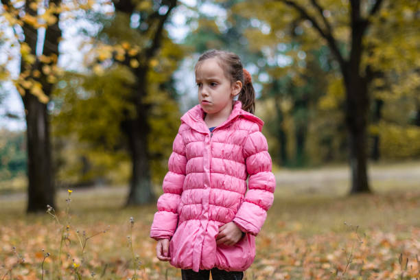 istock Sad child in autumn park 1283003109
