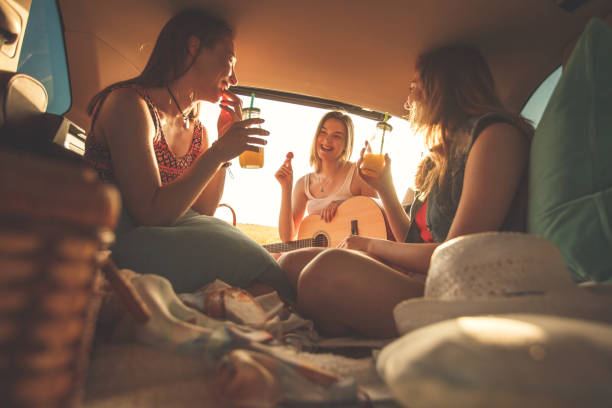 istock Girlfriends having fun at the back of a vehicle while camping 1283004249