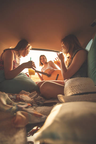 istock Girlfriends having fun while camping at the back of a vehicle 1283004254