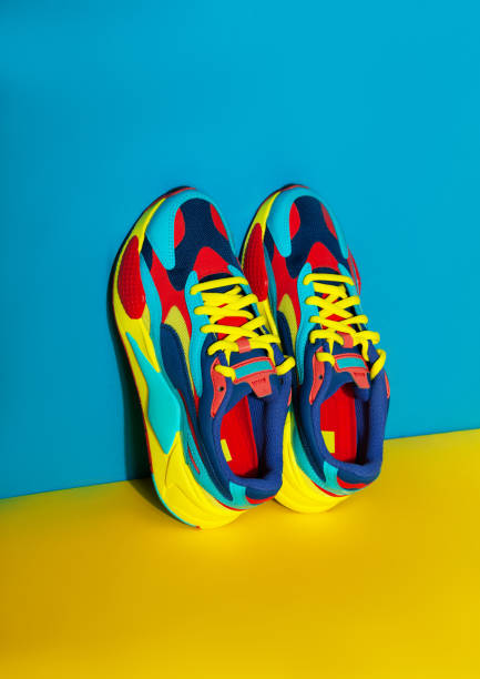 Multicolor sport shoes on yellow background with shadows