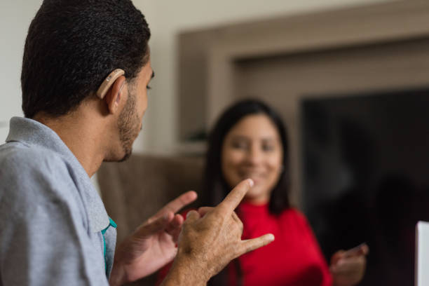 Deaf talking in sign language Deaf young people talking in sign language in the living room deafness photos stock pictures, royalty-free photos & images