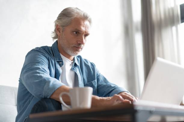 istock Middle-aged man working from home-office on laptop. 1283012300