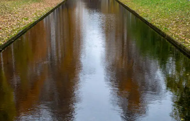 Photo of Water channel in the Park in autumn.A pond with still water