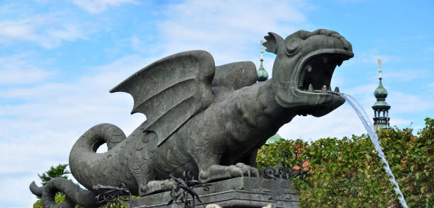 The famous landmark of Klagenfurt, medieval Dragon Fountain or the Lindwurmbrunnen, Austria. The Lindwurmbrunnen on the New Square in Klagenfurt am Wörthersee from the 16th century is the symbol of the city and represents the heraldic animal of the city, a dragon