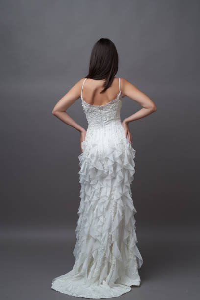 istock Beautiful bride in wedding dress posing on grey background 1283014738