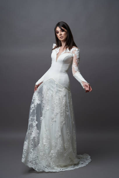 istock Beautiful bride in wedding dress posing on grey background 1283014753