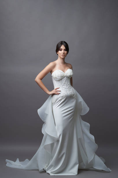 istock Beautiful bride in wedding dress posing on grey background 1283014756