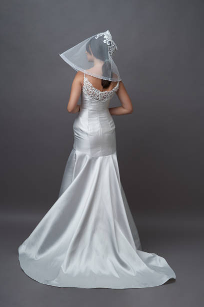 istock Beautiful bride in wedding dress posing on grey background with copy space. 1283014777