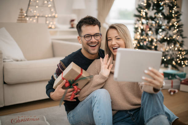 glückliches kaukasisches paar feiert weihnachten zu hause - christmas shopping internet family stock-fotos und bilder