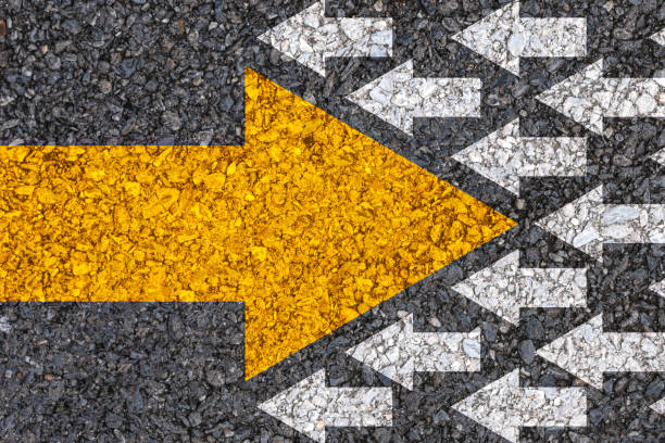 istock Different thinking and Business and technology disruption concept. Yellow big arrow opposite  direction with white arrow on road asphalt. 1283019180
