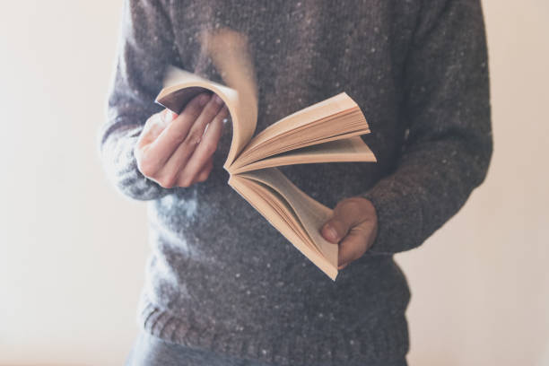 istock Man flipping through book pages close up 1283019611