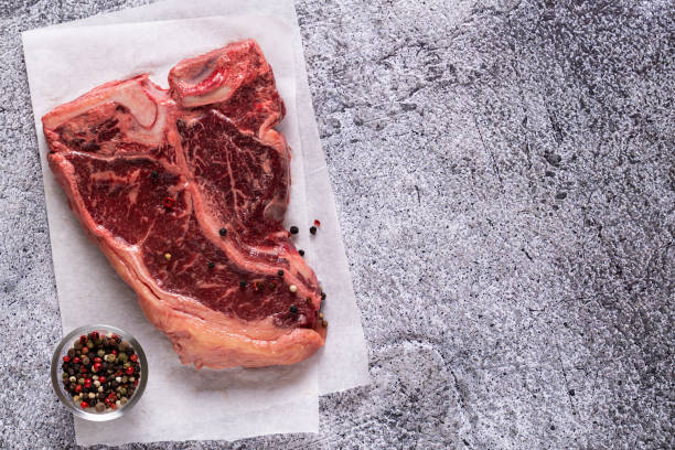 istock Fresh raw t-bone steak on gray stone background. 1283020434
