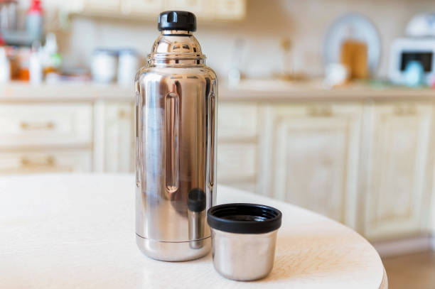 istock Close-up of steel thermos on white kitchen table 1283021144