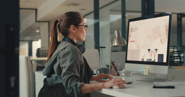 Adapting a brand strategy to suit her company's target market Shot of a young designer working on a computer in an office web designer stock pictures, royalty-free photos & images