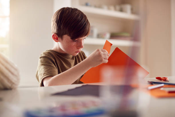 istock Boy At Home Having Fun Making Halloween Decorations 1283023744