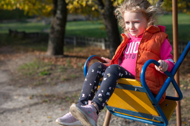 istock A little girl is riding a swing. 1283024472