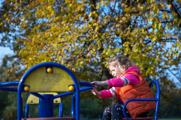 istock A little girl is riding a carousel. 1283024512