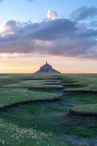 istock Mont St. Michel sunset view with green dry river bed in the foreground, horizontal 1283026077