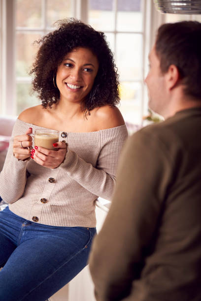 istock Couple Relaxing At Home Sitting At Kitchen Counter With Coffee 1283026816