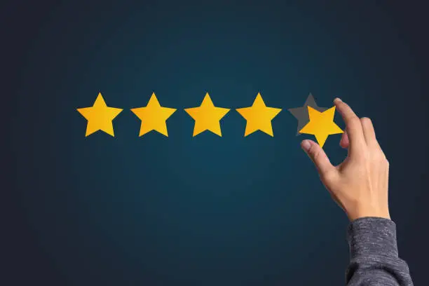 Photo of Customer satisfaction and product service evaluation concept , Hand holding and put yellow star to five stars with copy space.