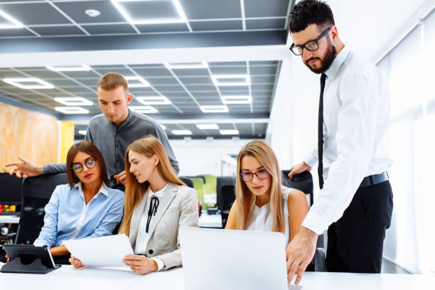 istock business team is working on a new project and smiling while sitting at their desk in a modern office to discuss the project 1283027035