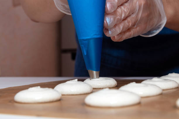 istock Using a pastry bag, spread the dough for macaroon dessert on parchment. Cooking process. 1283027124