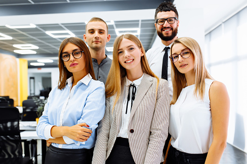 Successful business team standing together and smiling working in the office