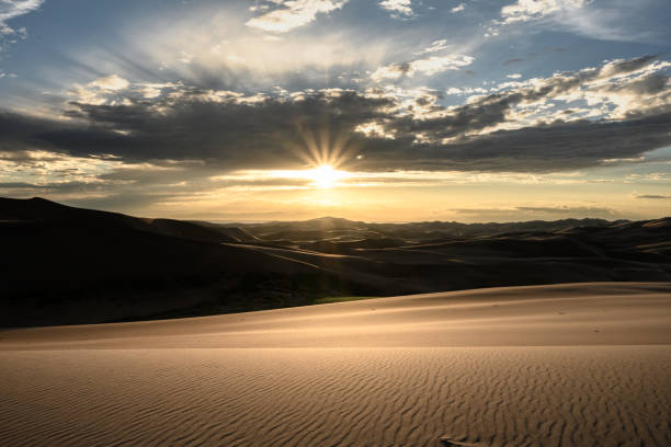 istock Sunburst Over Layers of Sand Dunes 1283028060