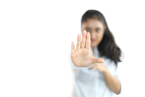 Young woman in formal wear making hand gesture indicating stop sign or enough.