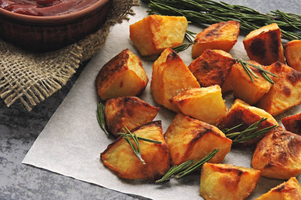 istock Baked potato chunks with rosemary and sauce. 1283030760