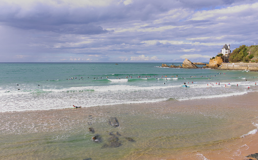 Biarritz beach in the Basque Country with surfers on a late afternoon light
