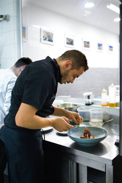 istock Young chef is preparing a typical with octopus dish of the restaurant. She brings to the table good and tasty cuisine 1283034681