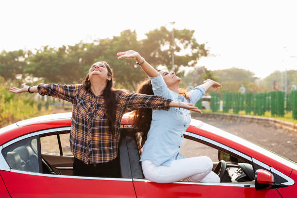 istock Girls having fun on road trip in car 1283035974