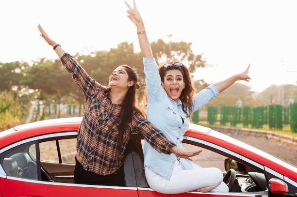 istock Girls having fun on road trip in car 1283036027