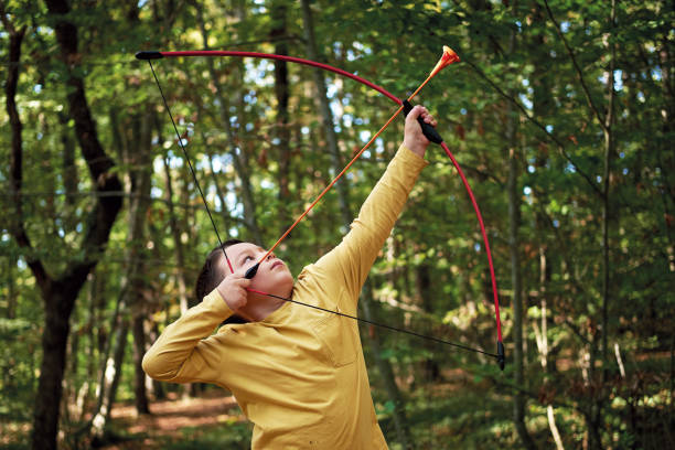istock 6-7 years old child on nature and using archery bow 1283038958